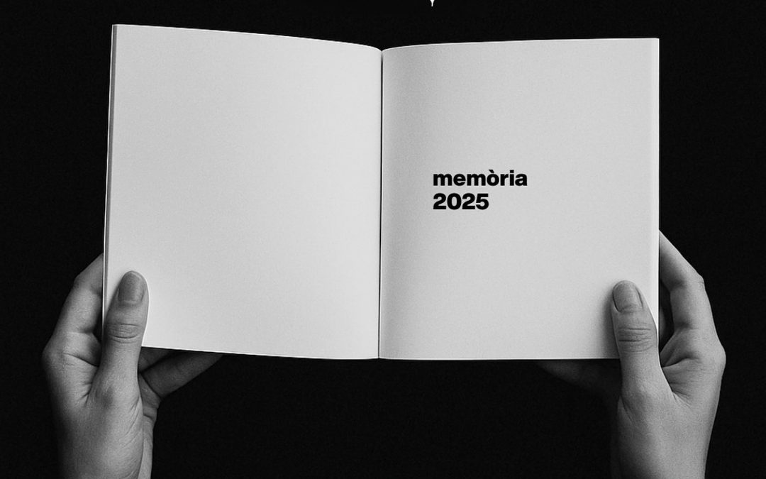 Imatge en blanc i negre d'unes mans sobre fons negre, subjectant una memòria en blanc amb les lletres: memòria 2025